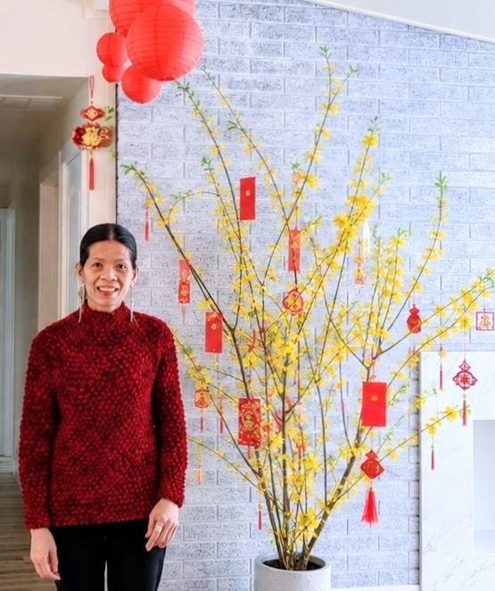Flowering trees — woman beside yellow blossoming Lunar New Year tree