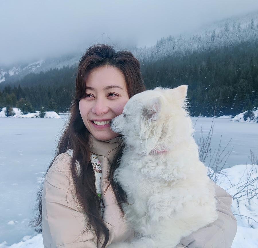Woman and white fluffy dog at snowy frozen lake — PhyTu Wellness